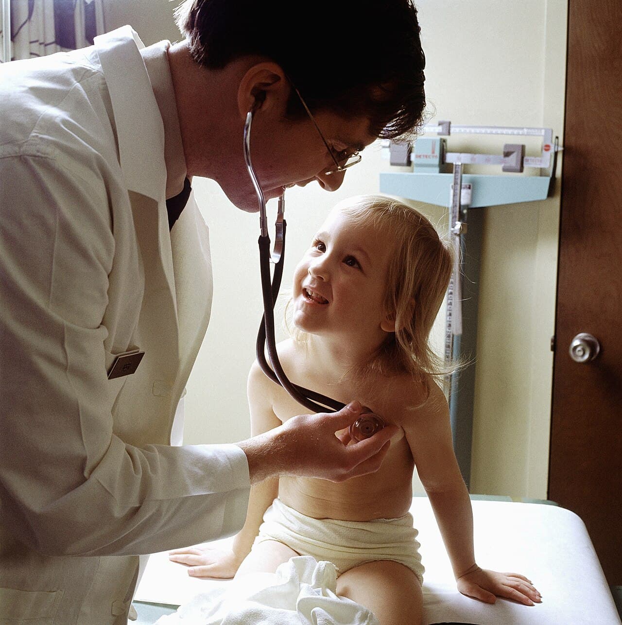 A doctor using a stethoscope to examine a young patient