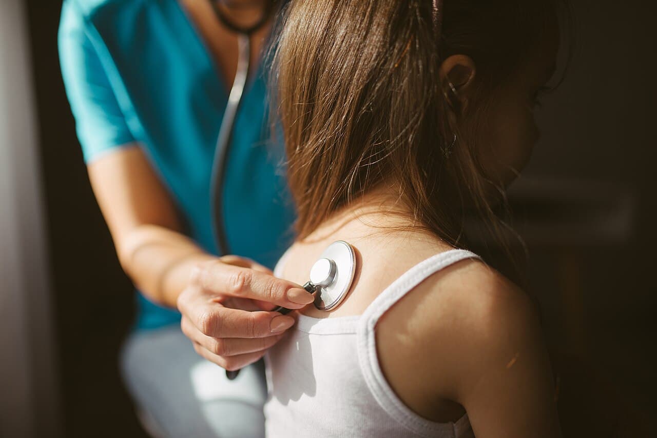 A doctor listening to a patient's chest with a stethoscope